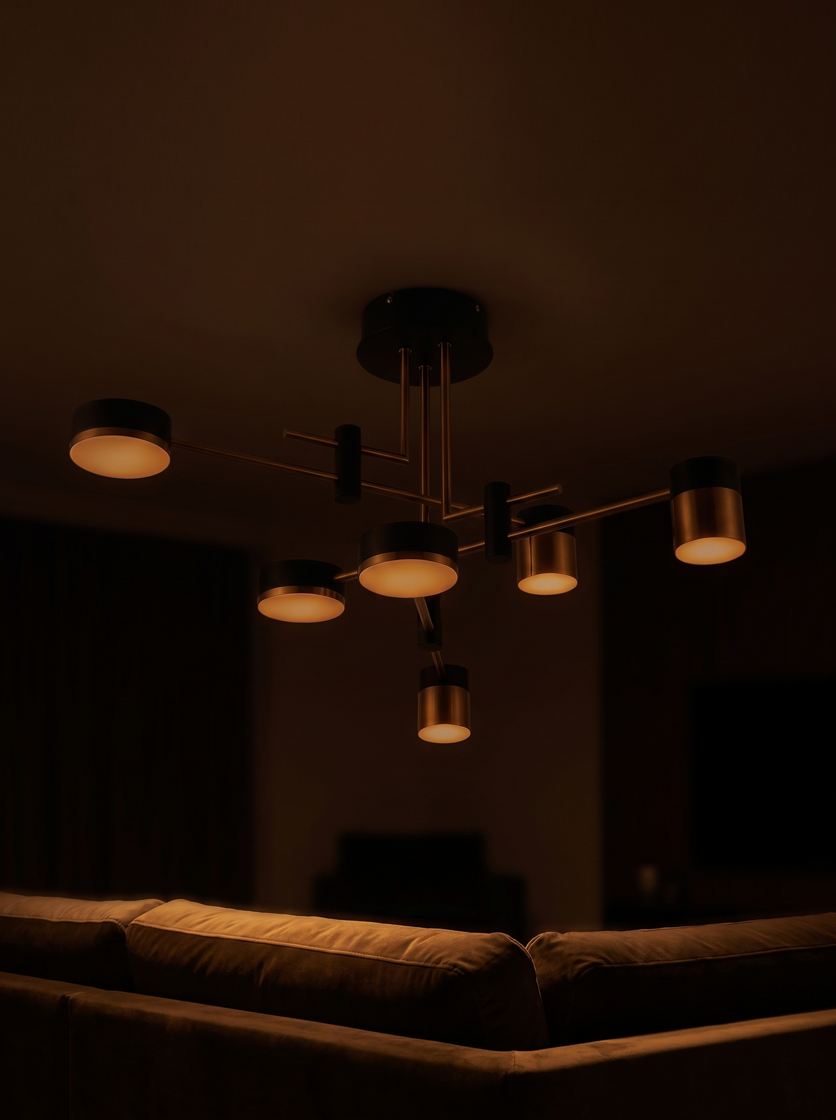 Astraeo chandelier dimmed to a low amber glow