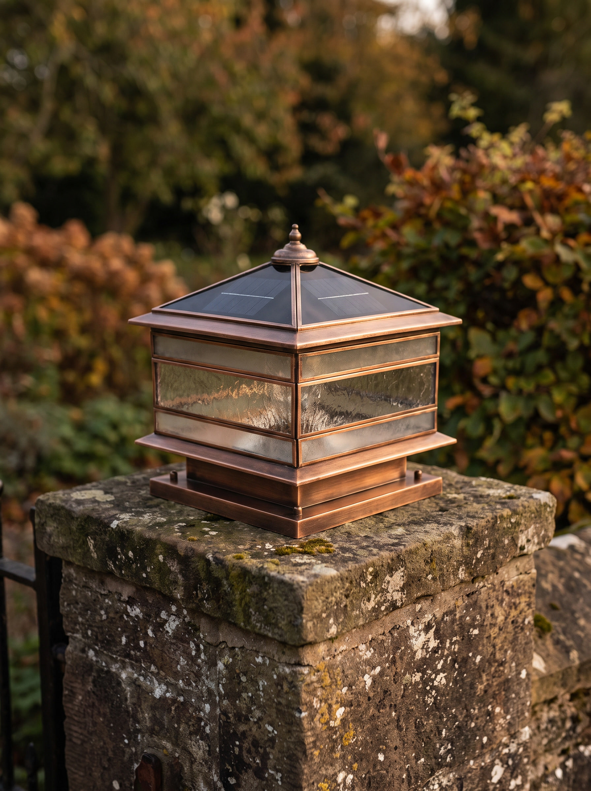 Brassano lantern with warm copper patina on a stone pillar