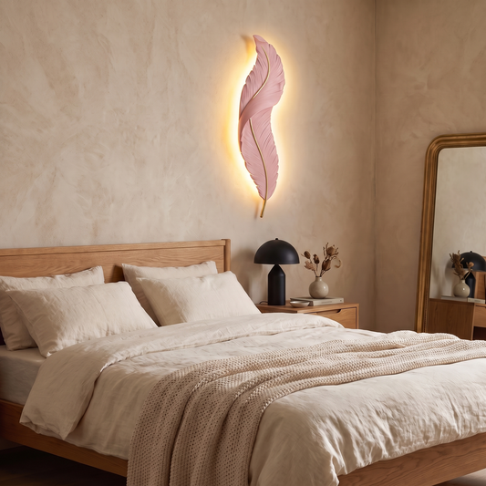Plumea sconce in pink on a plaster wall beside a bed in the evening