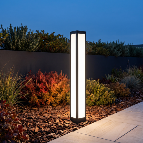 Verdano bollard light at 31 inches in a mulch planting bed beside a stone path