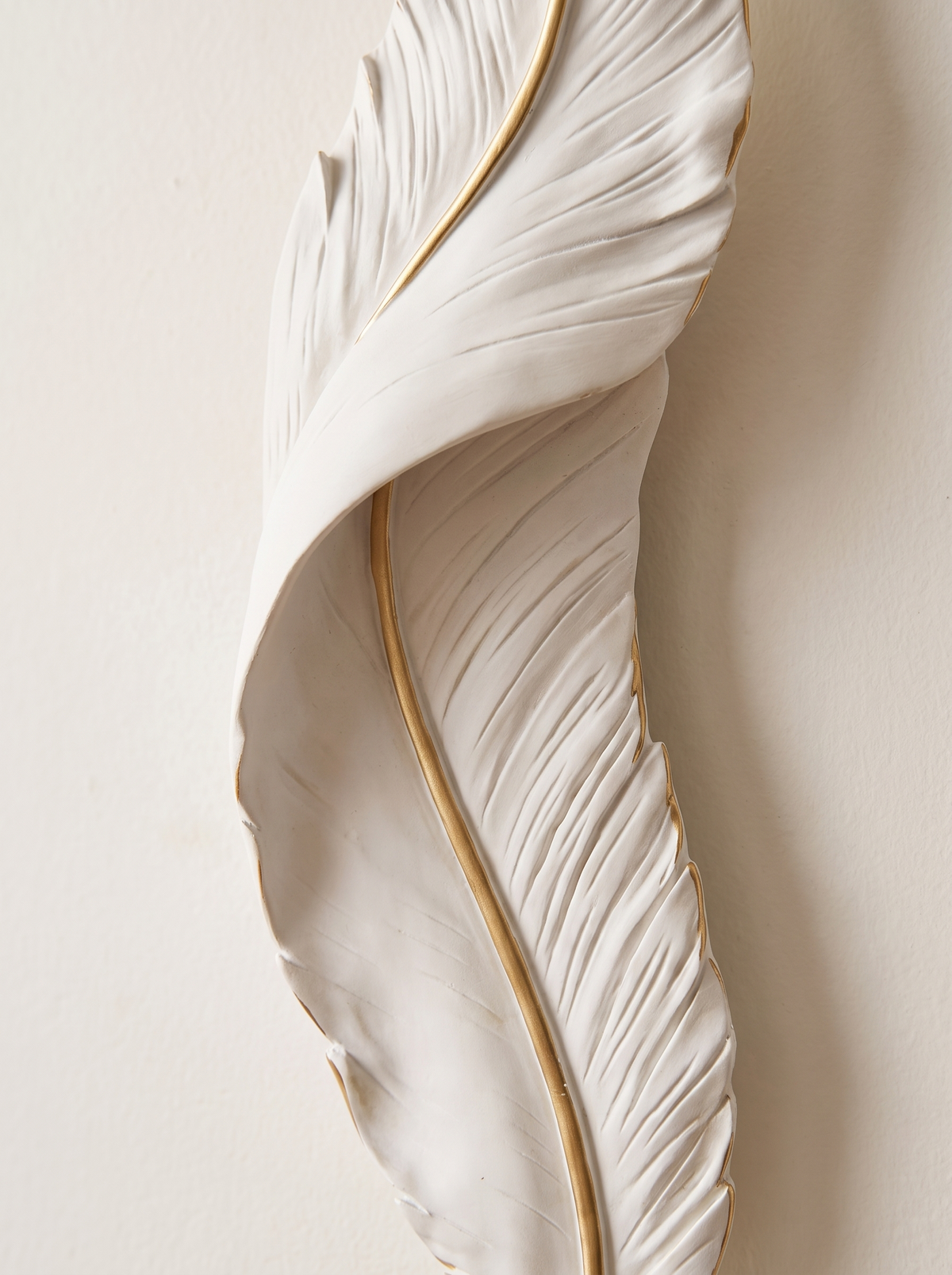 Close detail of the Plumea resin feather and gold edge